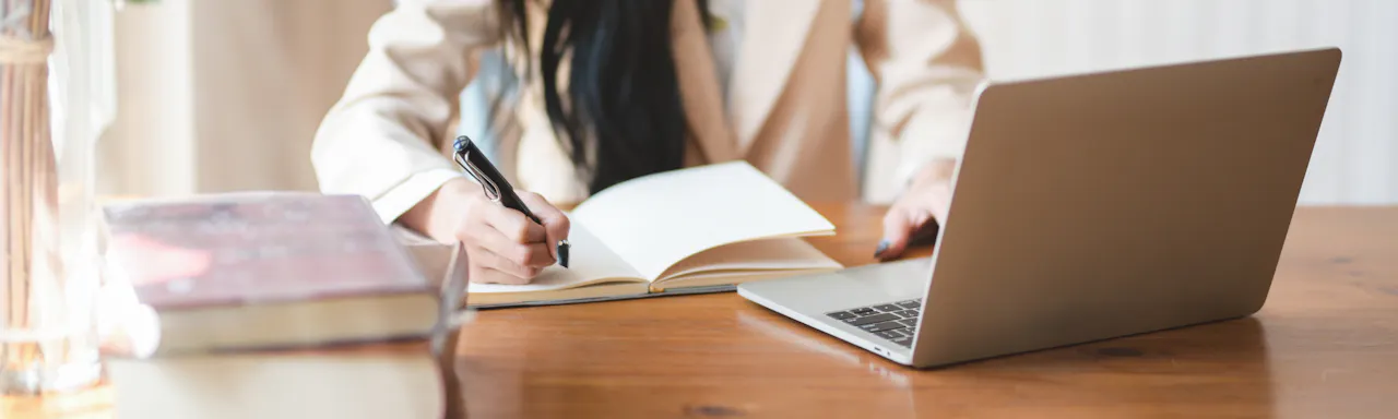 Woman Writing on Notebook